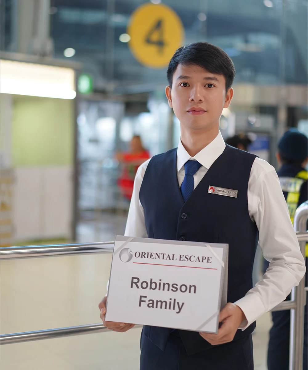Airport representative meeting guests with a name sign